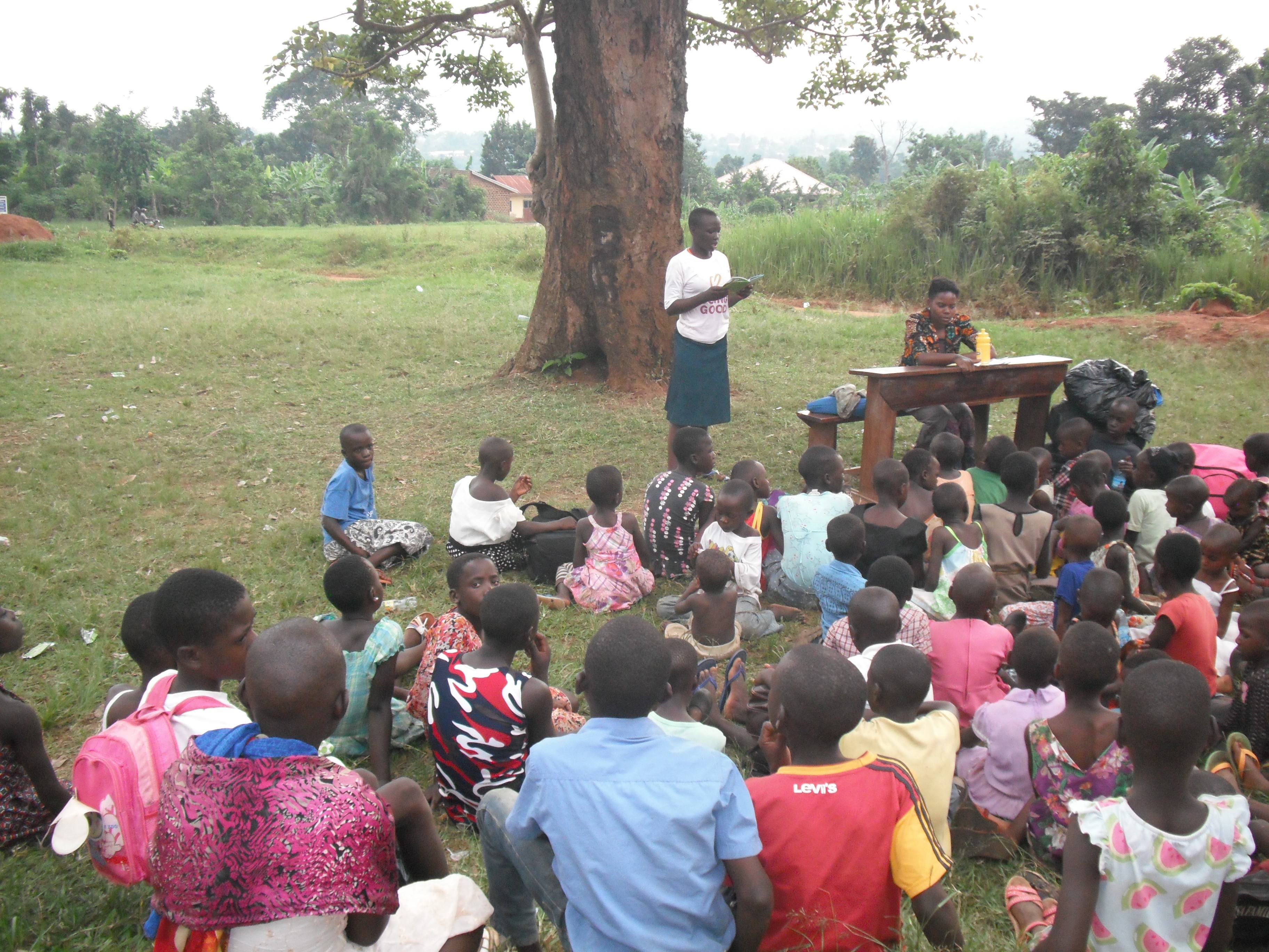 Children having reading classes under a tree shade