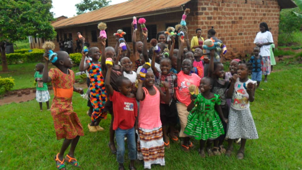 Children posing after receiving knitted items